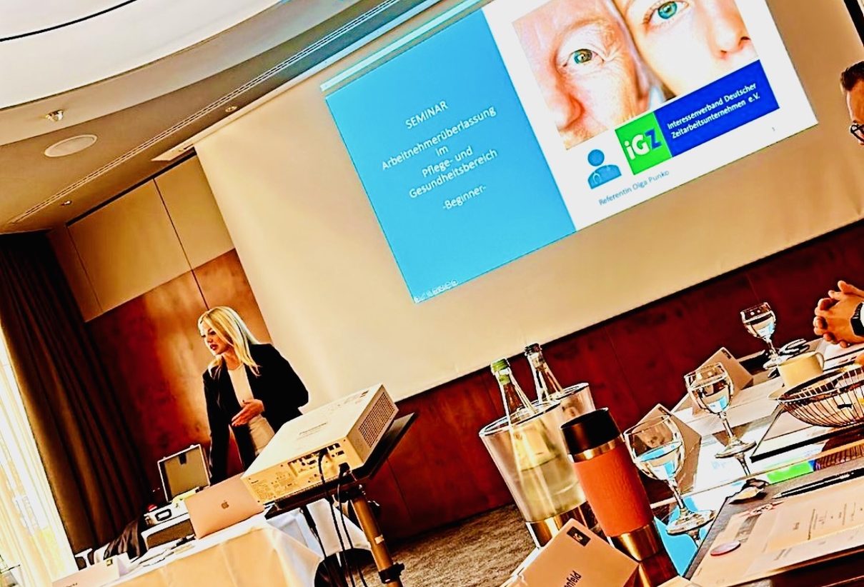 „Seminarleitung hält Vortrag über Arbeitnehmerüberlassung im Pflege- und Gesundheitsbereich – Schulungssituation mit Präsentation.“
